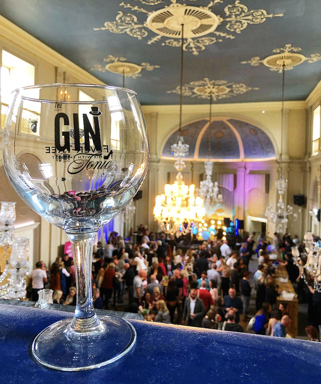 A Hand Holding a Gin Glass in front of an event