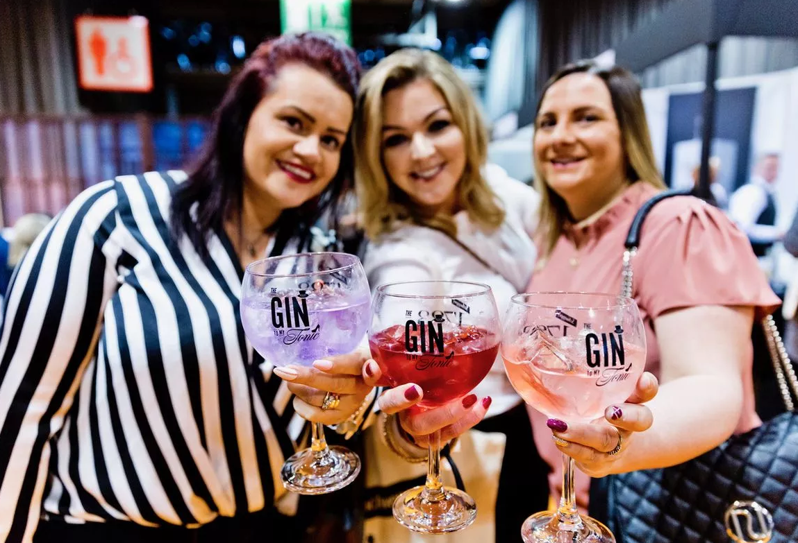 Three ladies holding a giTMT glass, and smiling